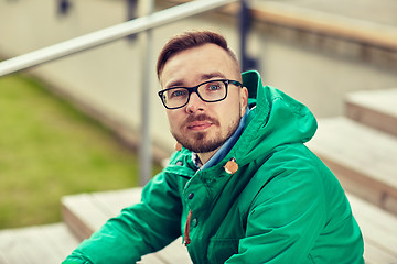 Image showing happy young hipster man sitting on stairs in city