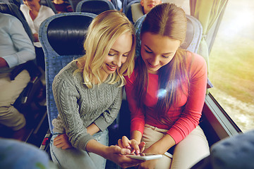 Image showing happy young women in travel bus with smartphone