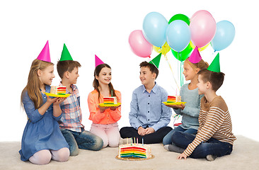 Image showing happy children in party hats with birthday cake