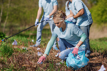 Image showing volunteers with garbage bags cleaning park area