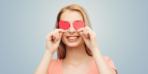 Image showing happy young woman with red heart shapes on eyes