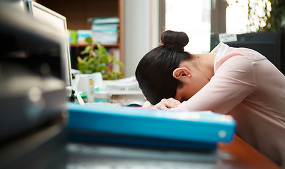 Image showing Tired businesswoman sleeping on the desk.