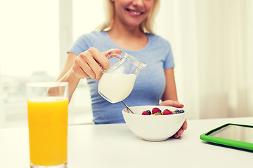 Image showing close up of woman with milk jug eating breakfast