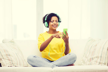 Image showing happy african woman with smartphone and headphones