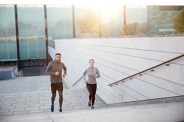 Image showing happy couple running upstairs on city stairs