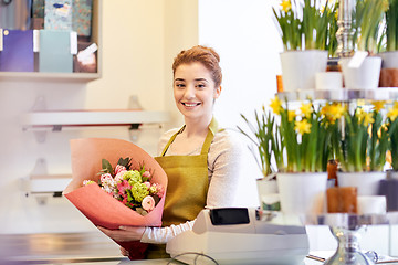 Image showing smiling florist woman with bunch at flower shop