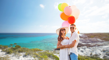 Image showing smiling couple with air balloons outdoors