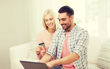 Image showing happy couple with laptop and credit card at home