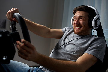 Image showing man playing car racing video game at home