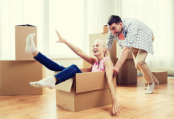 Image showing couple with cardboard boxes having fun at new home