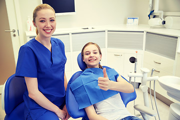 Image showing happy female dentist with patient girl at clinic