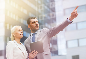 Image showing businesspeople with tablet pc over office building