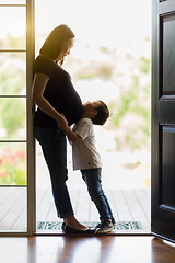 Image showing Young Son Hugging Pregnant Mom in Doorway