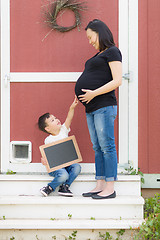 Image showing Son with Blank Chalk Board Pointing to Pregnant Belly of Mommy