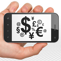 Image showing News concept: Hand Holding Smartphone with Finance Symbol on display