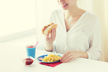 Image showing close up of woman eating hotdog and french fries