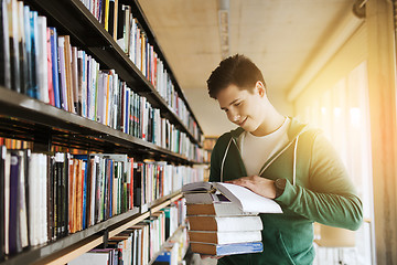 Image showing happy student or man with book in library