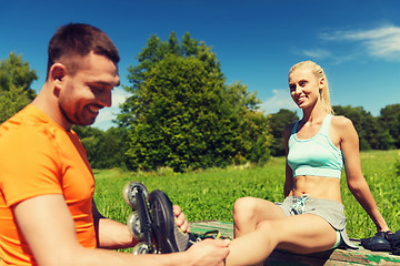 Image showing happy couple with rollerblades outdoors