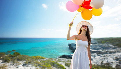 Image showing smiling young woman in sunglasses with balloons