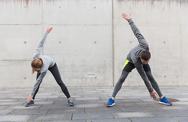 Image showing couple stretching on city street