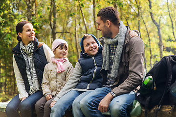 Image showing happy family sitting on bench and talking at camp