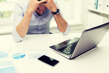 Image showing businessman with laptop and papers in office
