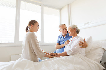 Image showing happy family visiting senior woman at hospital