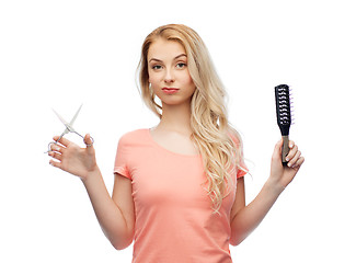 Image showing young woman with scissors and hairbrush