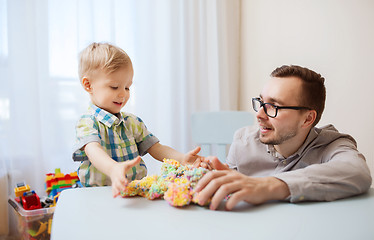 Image showing father and son playing with ball clay at home