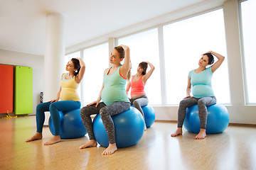 Image showing happy pregnant women exercising on fitball in gym