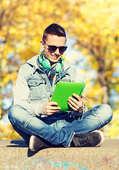 Image showing happy young man with tablet pc and headphones