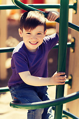 Image showing happy little boy climbing on children playground