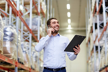 Image showing man with clipboard and smartphone at warehouse