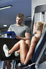 Image showing man and woman flexing muscles on gym machine