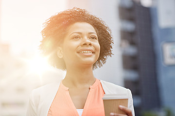 Image showing happy african businesswoman with coffee in city