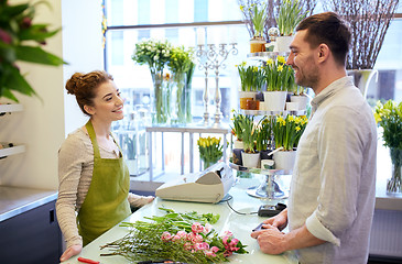 Image showing smiling florist woman and man at flower shop