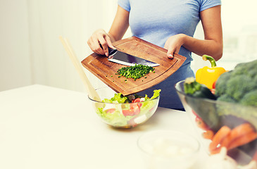 Image showing close up of woman with chopped onion cooking salad