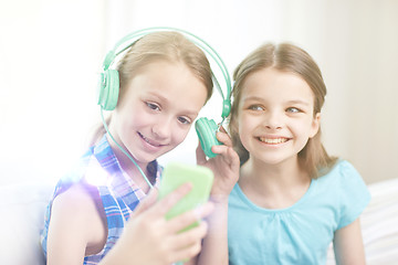 Image showing happy girls with smartphone and headphones