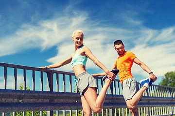 Image showing smiling couple stretching outdoors