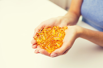 Image showing close up of woman hands holding pills or capsules