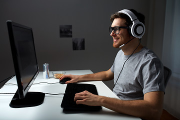 Image showing man in headset playing computer video game at home