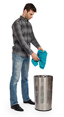 Image showing Young man putting a dirty towel in a laundry basket