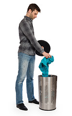 Image showing Young man putting a dirty towel in a laundry basket