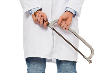 Image showing Crazy doctor is holding a big saw in his hands