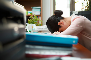 Image showing Tired businesswoman sleeping on the desk.