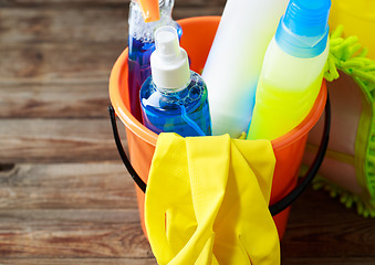 Image showing Plastic bucket with cleaning supplies on wood background