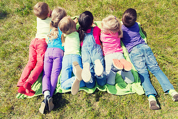 Image showing group of kids lying on blanket or cover outdoors
