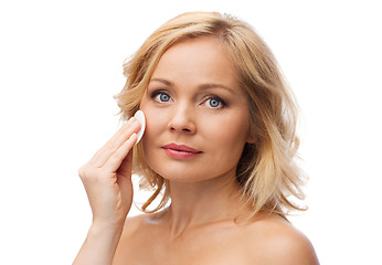 Image showing happy woman cleaning face with cotton pad