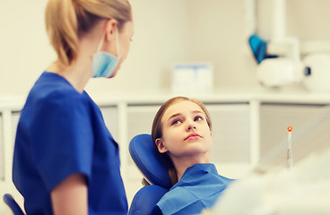 Image showing happy female dentist with patient girl at clinic