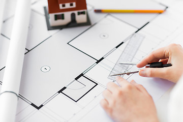 Image showing close up of hands with compass measuring blueprint